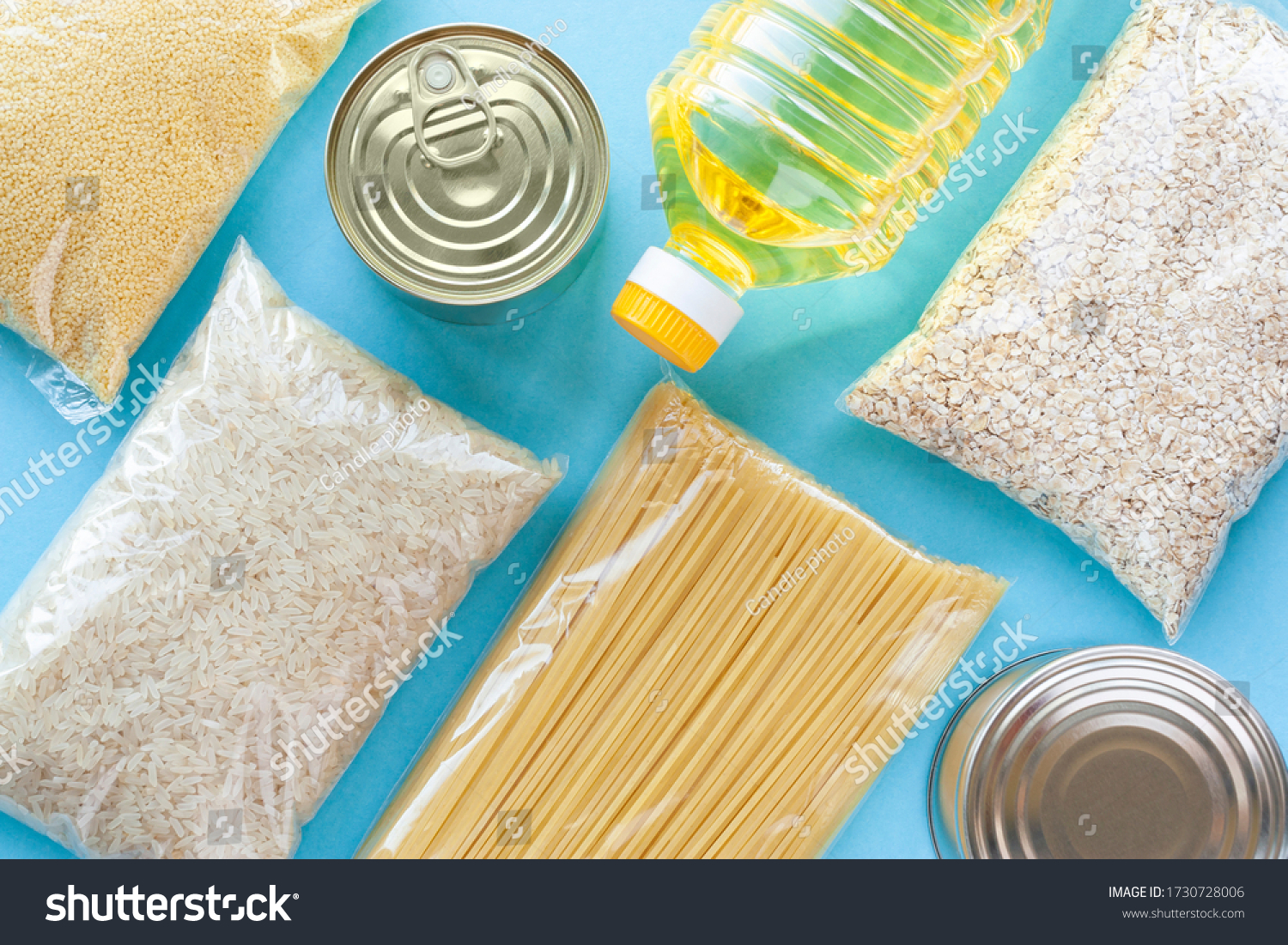 Set of grocery items from pasta, rice, oatmeal, couscous, oil and canned food on blue background. Food delivery, donation or stock provision concept. Top view, flat lay. #1730728006