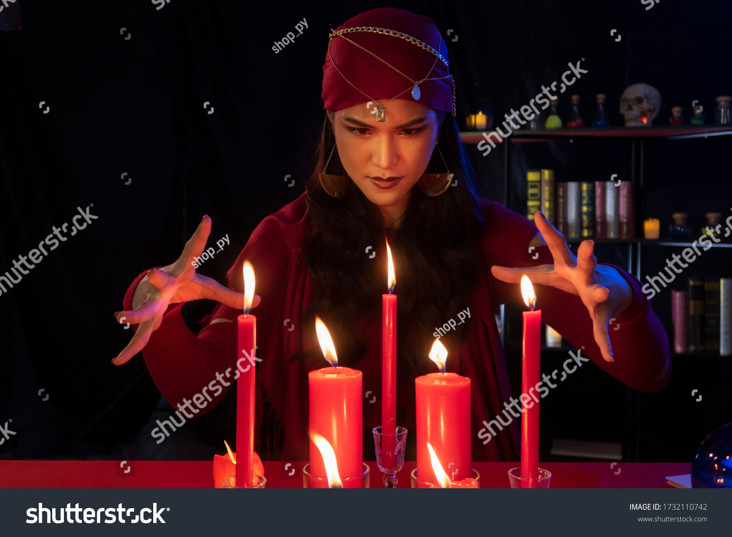 Beautiful Gypsy fortune teller woman casting a magical spell over candle while predicting the future. Divine magic, Forecast esoteric astrology superstition, magical power, alchemy, Black magic. #1732110742
