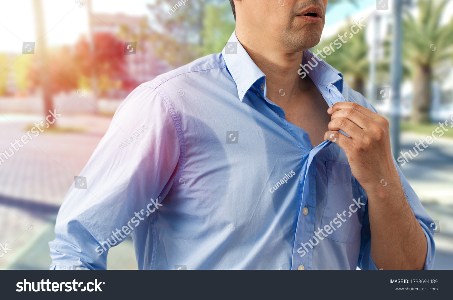 Shot of an unrecognizable man undressing because of the heat and sweat on a hot summer day #1738694489