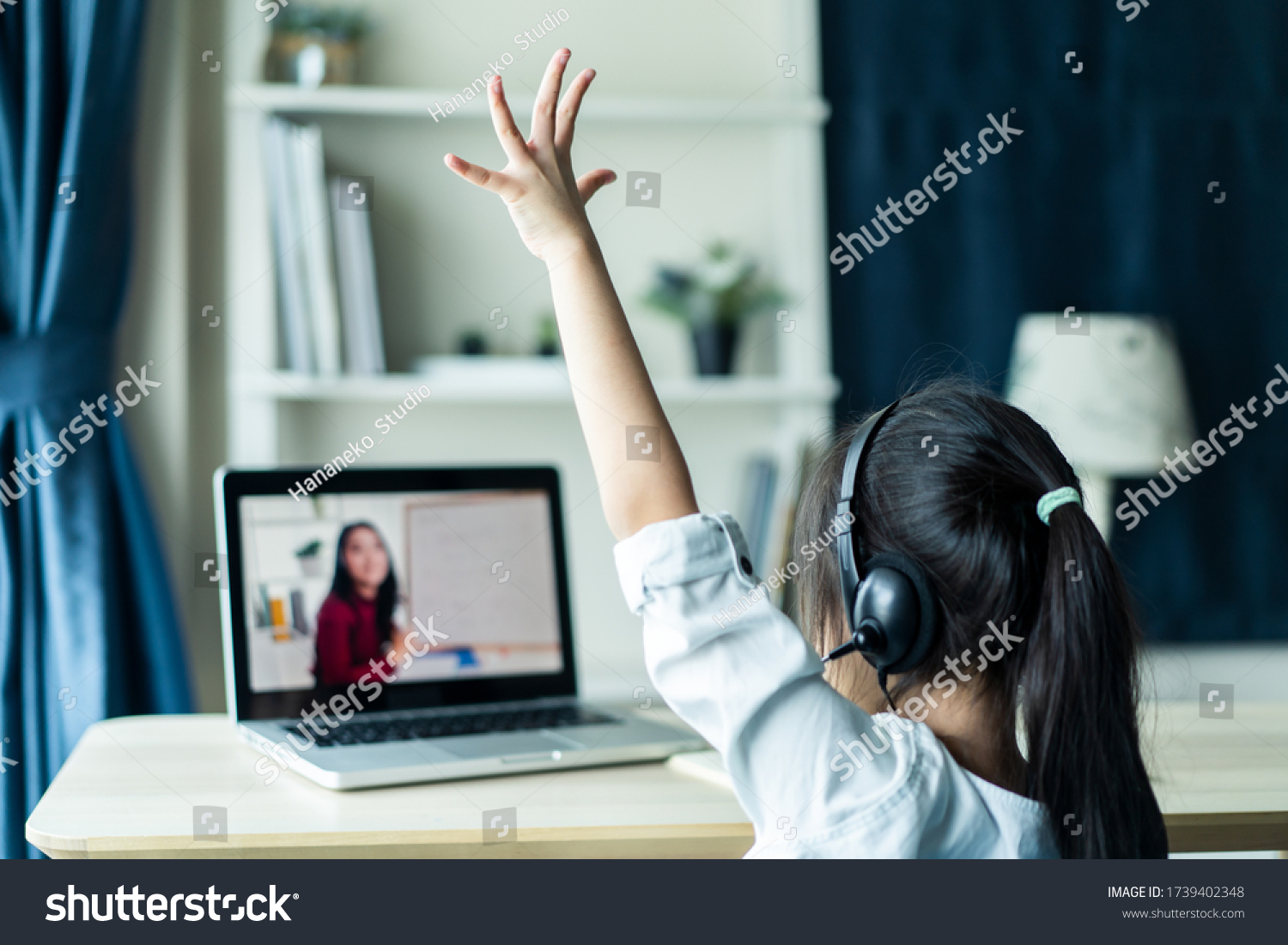 Homeschool Asian little young girl student learning virtual internet online class from school teacher by remote meeting due to covid pandemic. Female teaching math by using headphone and whiteboard. #1739402348
