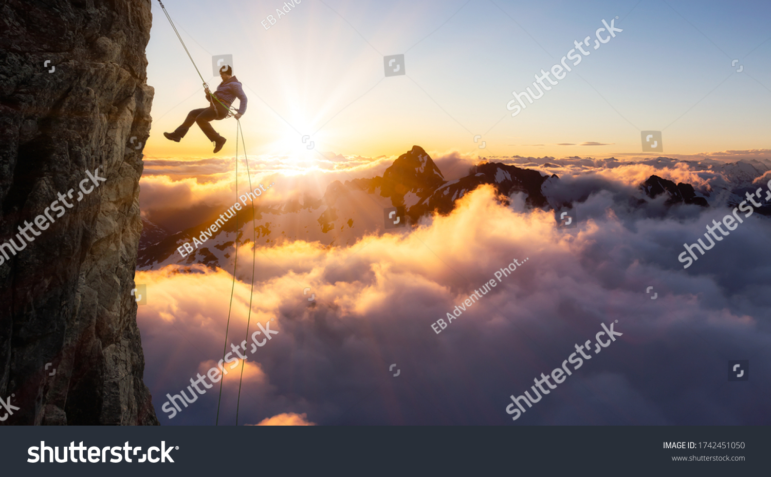 Epic Adventurous Extreme Sport Composite of Rock Climbing Man Rappelling from a Cliff. Mountain Landscape Background from British Columbia, Canada. Concept: Explore, Hike, Adventure, Lifestyle #1742451050