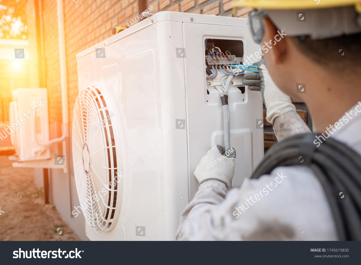 Air Conditioning Technician and A part of preparing to install new air conditioner. Technician vacuum pump evacuates and checking new air conditioner #1745619830