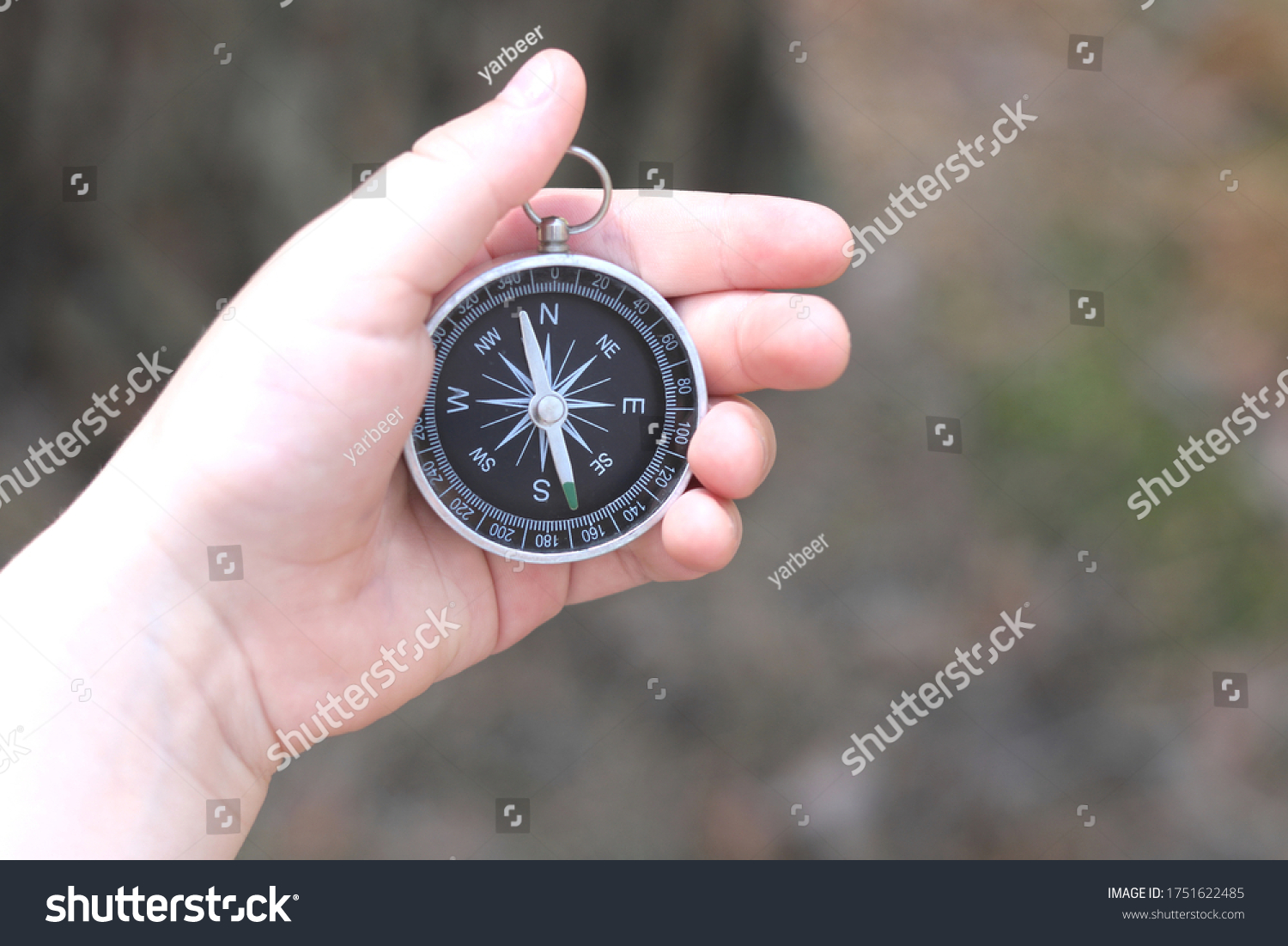 Old classic navigation compass in childs hand on natural background #1751622485
