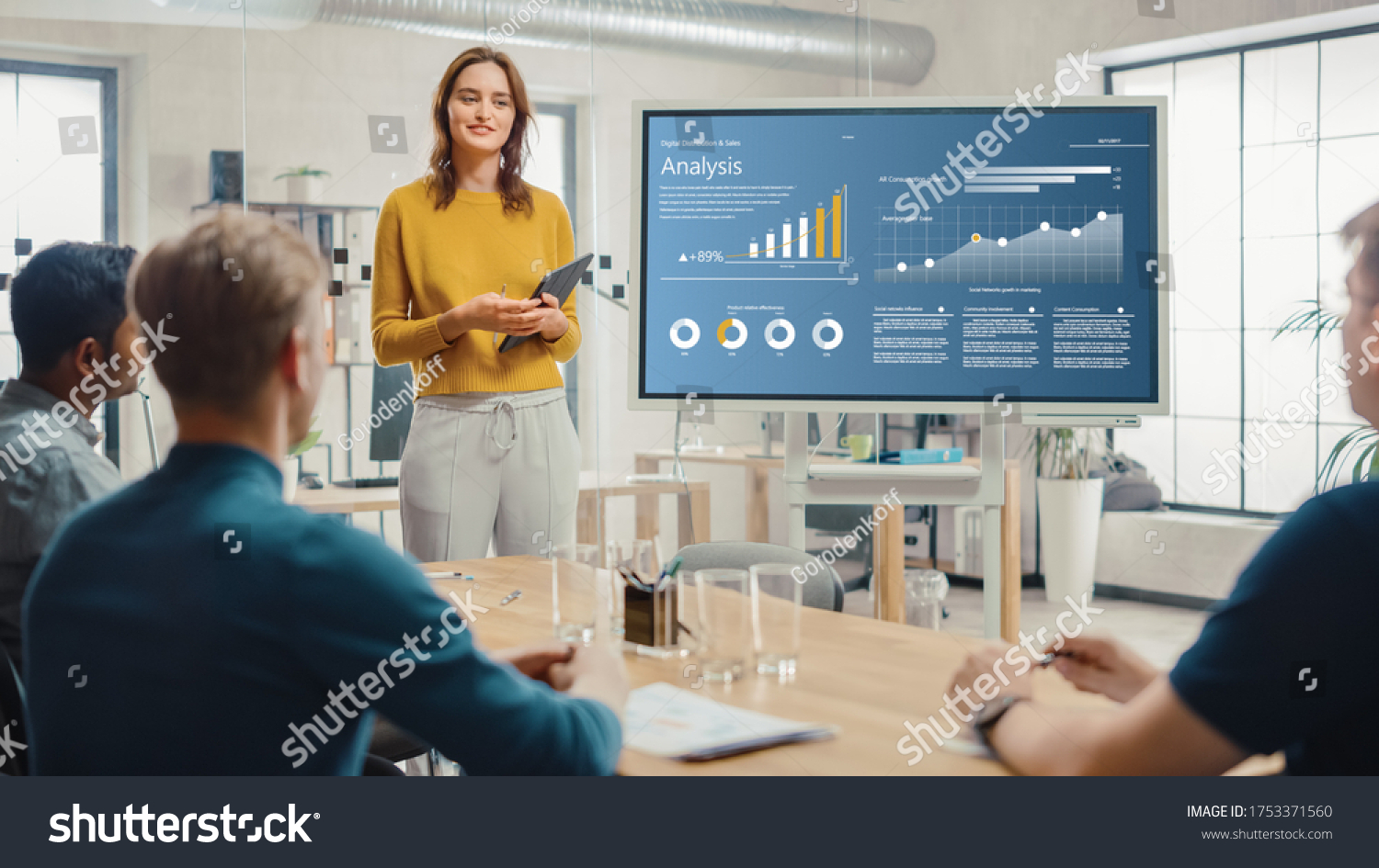 Female Chief Analyst Holds Meeting Presentation for a Team of Economists. She Shows Digital Interactive Whiteboard with Growth Analysis, Charts, Statistics and Data. People Work in Creative Office. #1753371560