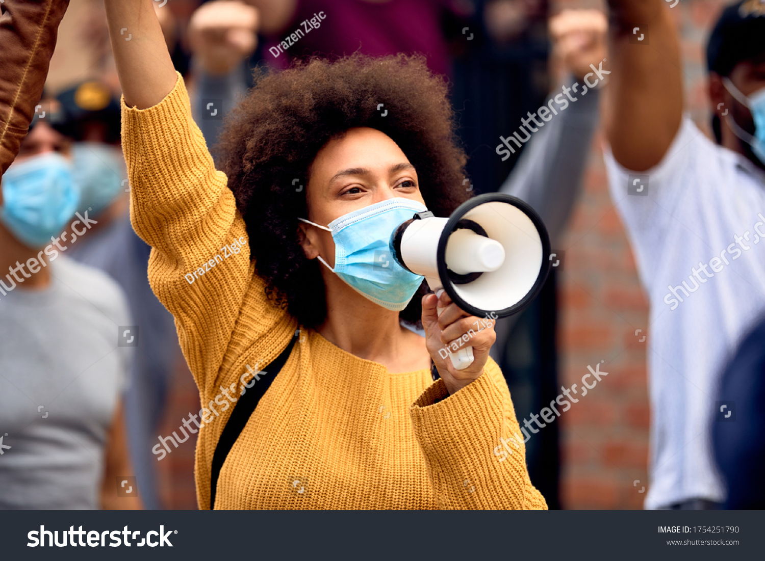 Young African American woman shouting through megaphones while supporting anti-racism protests.  #1754251790