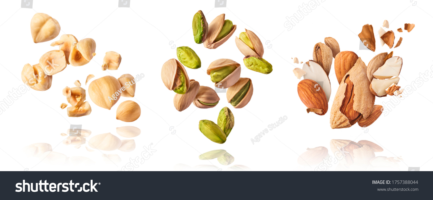 A set with Flying in air fresh raw whole and cracked pistachios, almonds and hazelnut isolated on white background. Concept of Pistachios almonds and hazelnut is torn to pieces close-up. #1757388044
