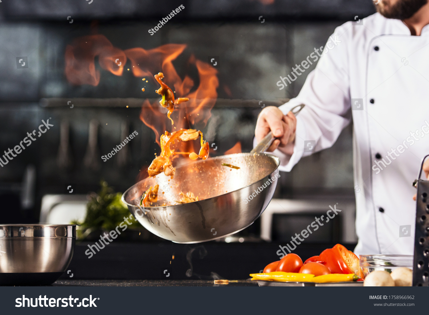 Chef hands keep wok with fire. Closeup chef hands cook food with fire. Chef man burn food at professional kitchen. #1758966962