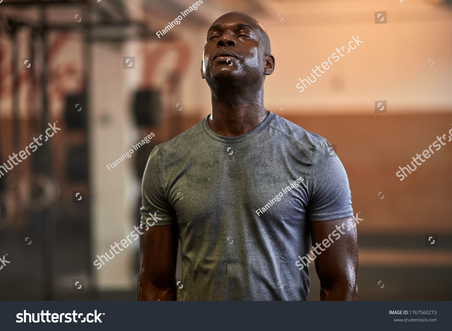 Fit young African American man standing with his eyes closed and sweating after a gym workout #1767560273