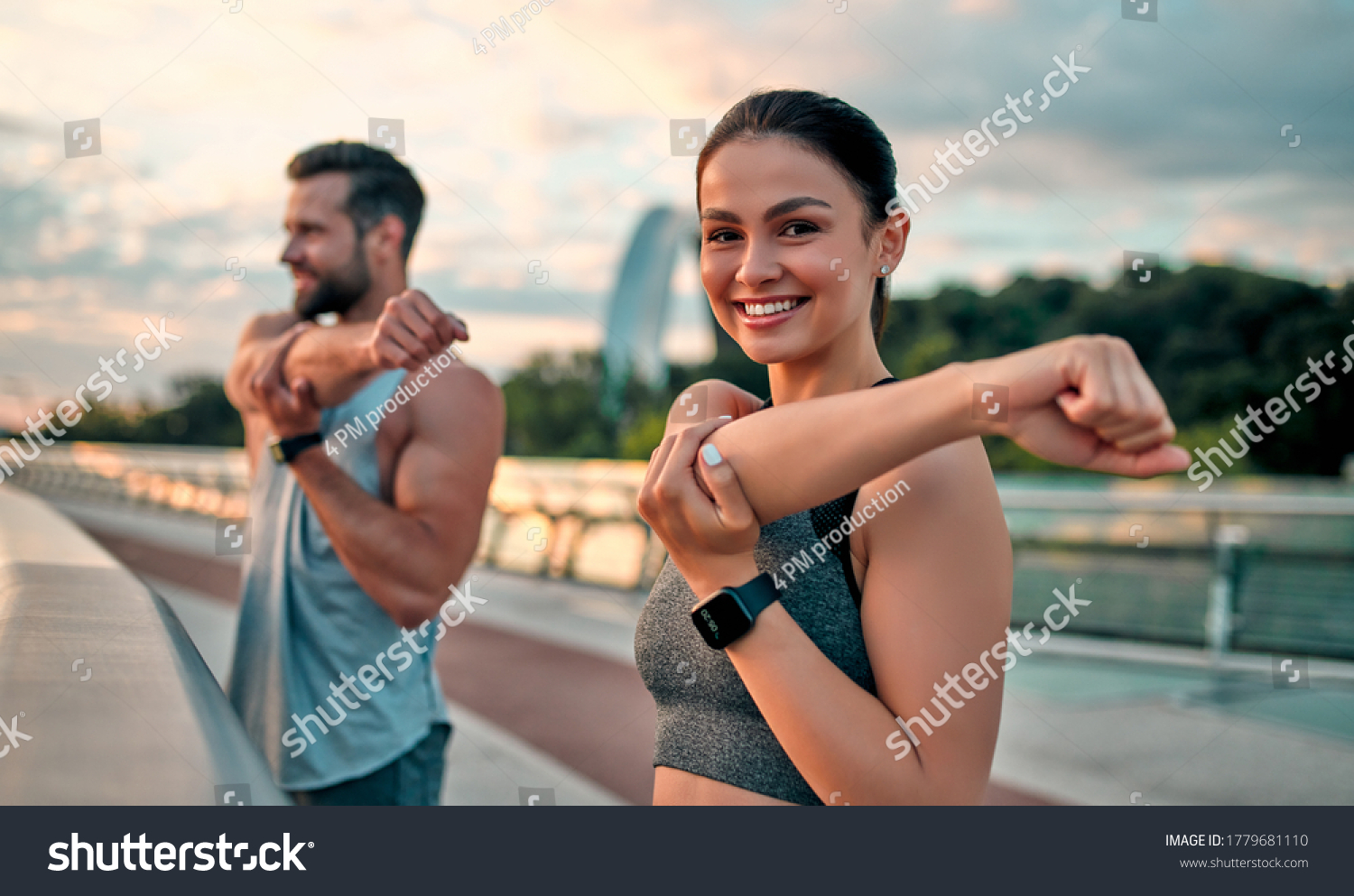 Couple stretching outdoors before morning run. Handsome bearded man and attractive sporty woman running on the street. #1779681110
