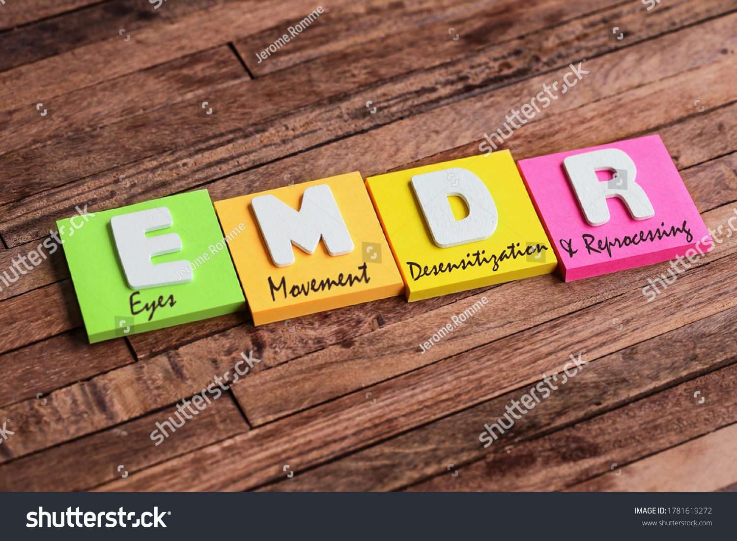 Colorful square papers with wooden white letters for the English acronym word, EMDR #1781619272