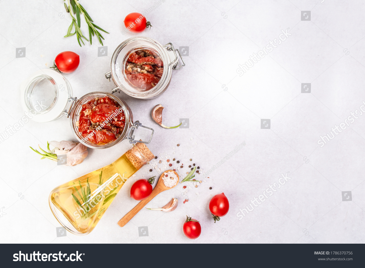 Sun dried tomatoes with garlic, oregano, olive oil in a jar on a light table, banner, menu recipe place for text, top view. #1786370756