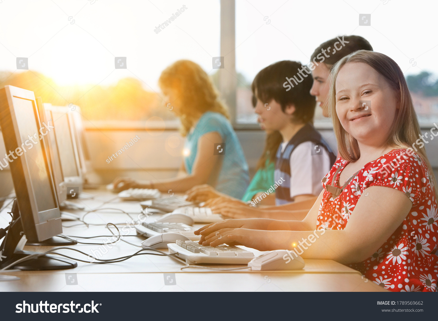Girl with Down syndrome using computer at school #1789569662