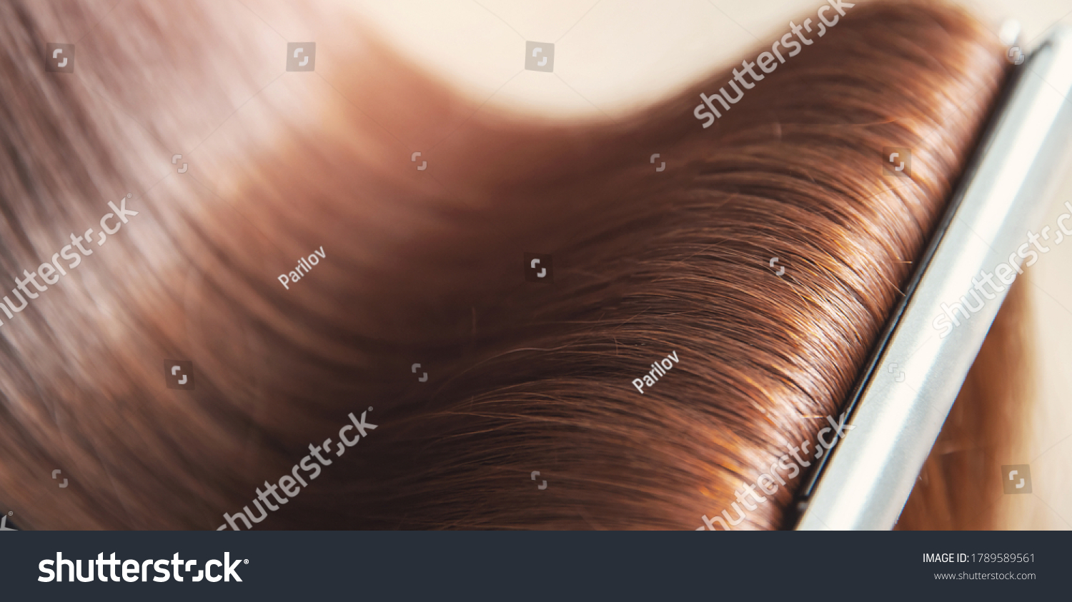 Close up hands of professional hairdresser beauty salon, straighteners curling female hair. #1789589561