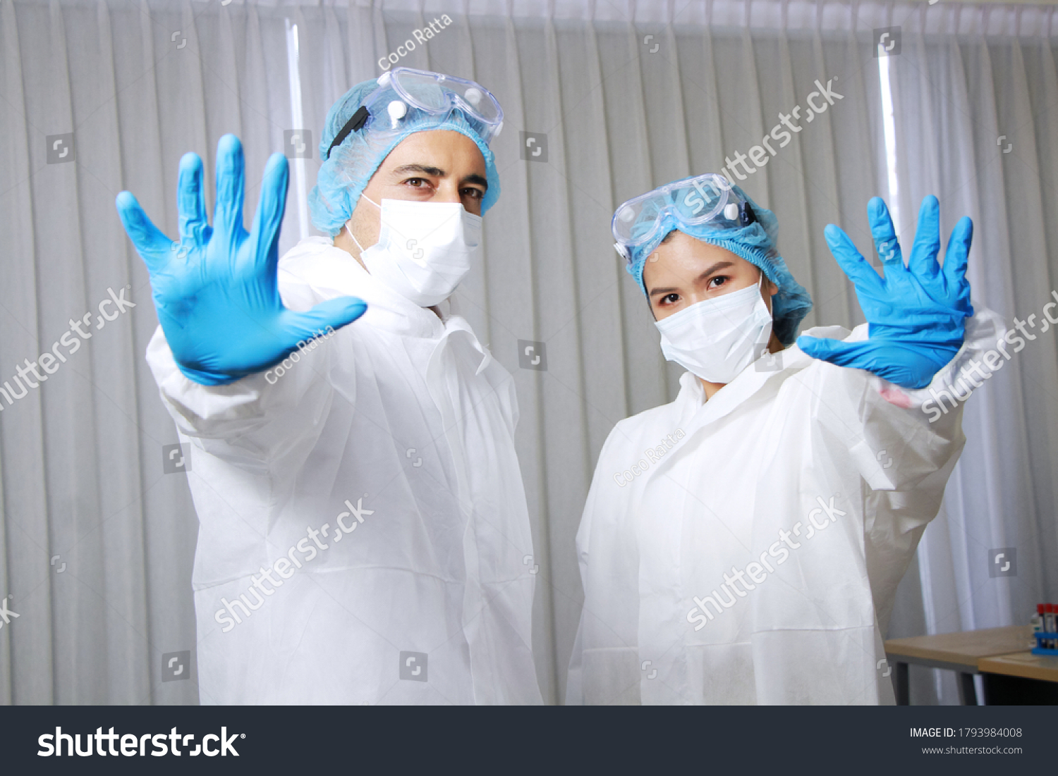 Powerful of Medical team in Personal Protective Equipment or PPE clothing and Healing for patient and showing stop hand sign for Covid-19 virus pathogens and inhibit the spread of germs. #1793984008