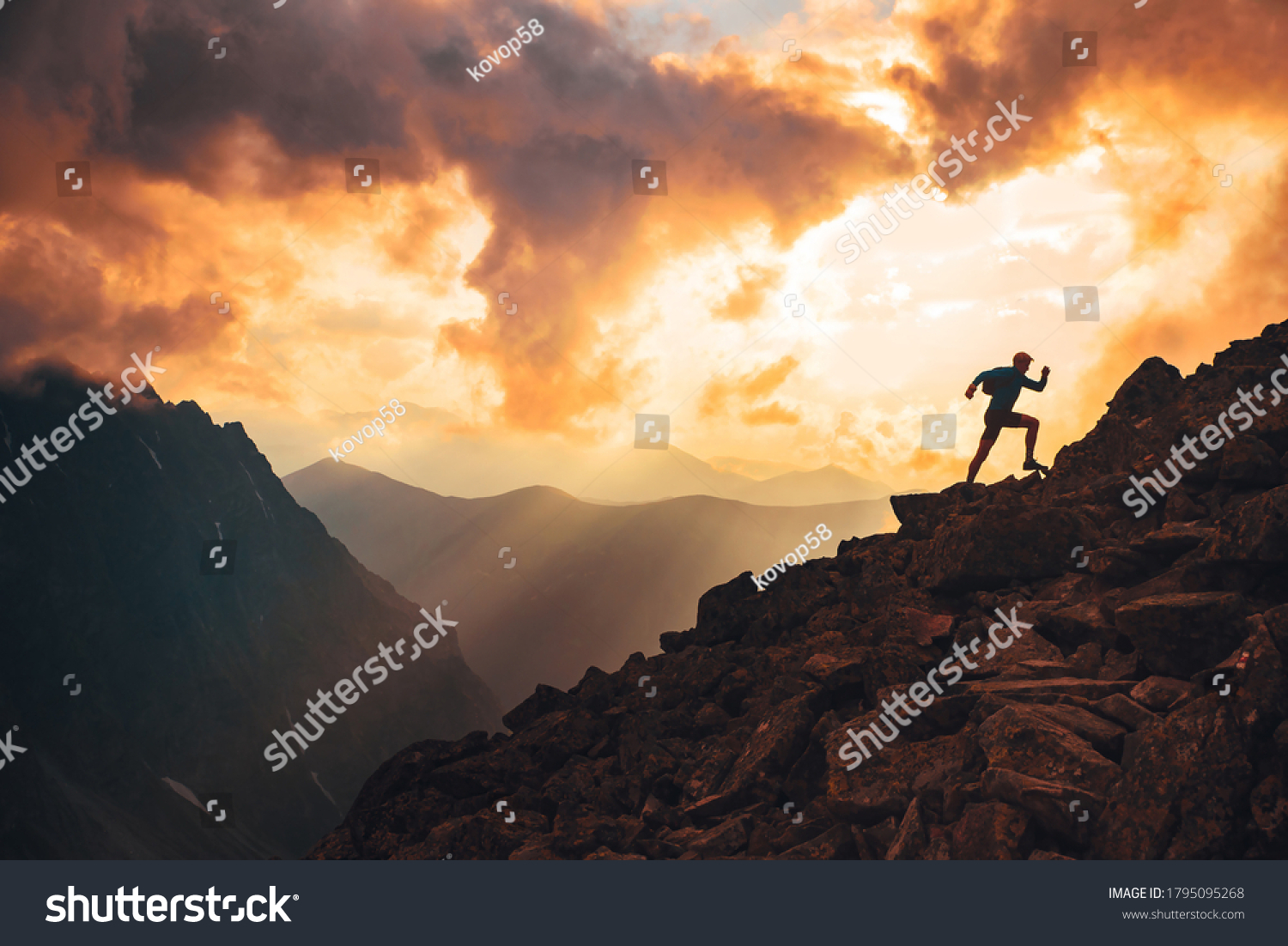 Trail runner in evening summer mountains. sunset sky and edit space in background #1795095268