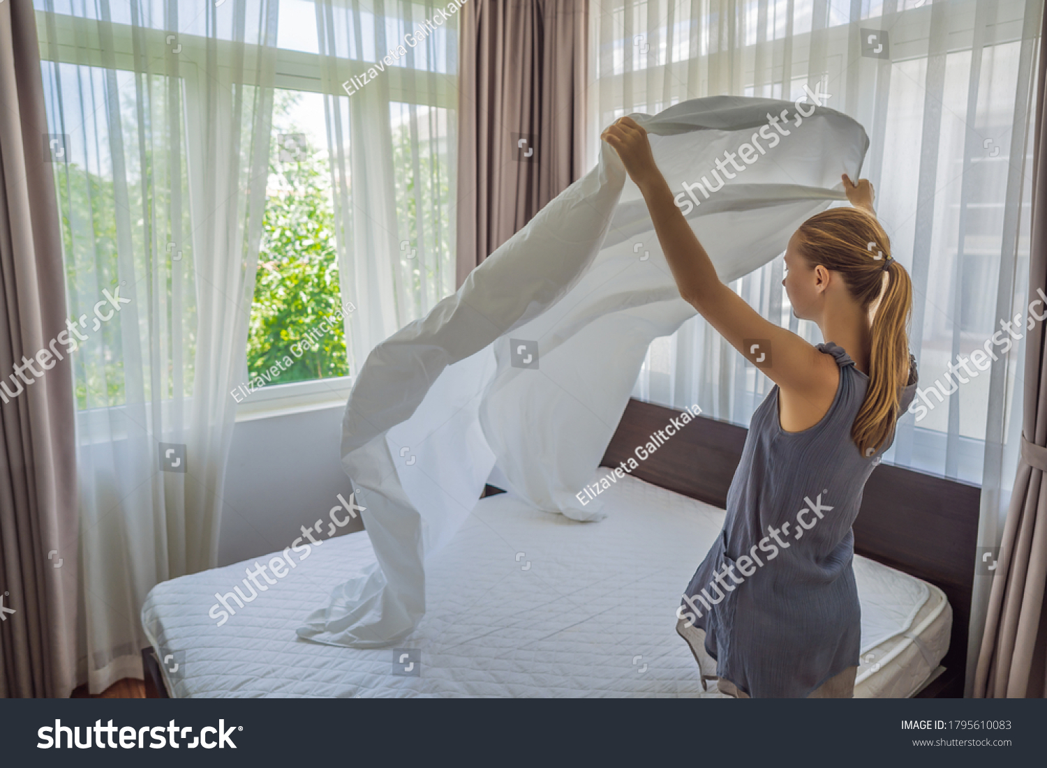 Young Female Housekeeper Changing Bedding In Hotel Room #1795610083