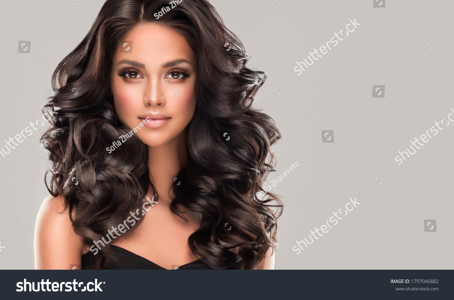 Beauty brunette girl with long  and   shiny wavy black hair .  Beautiful   woman model with curly hairstyle . #1797046882