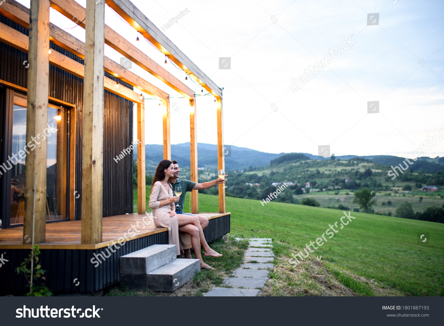 Young couple with wine outdoors, weekend away in container house in countryside. #1801887193