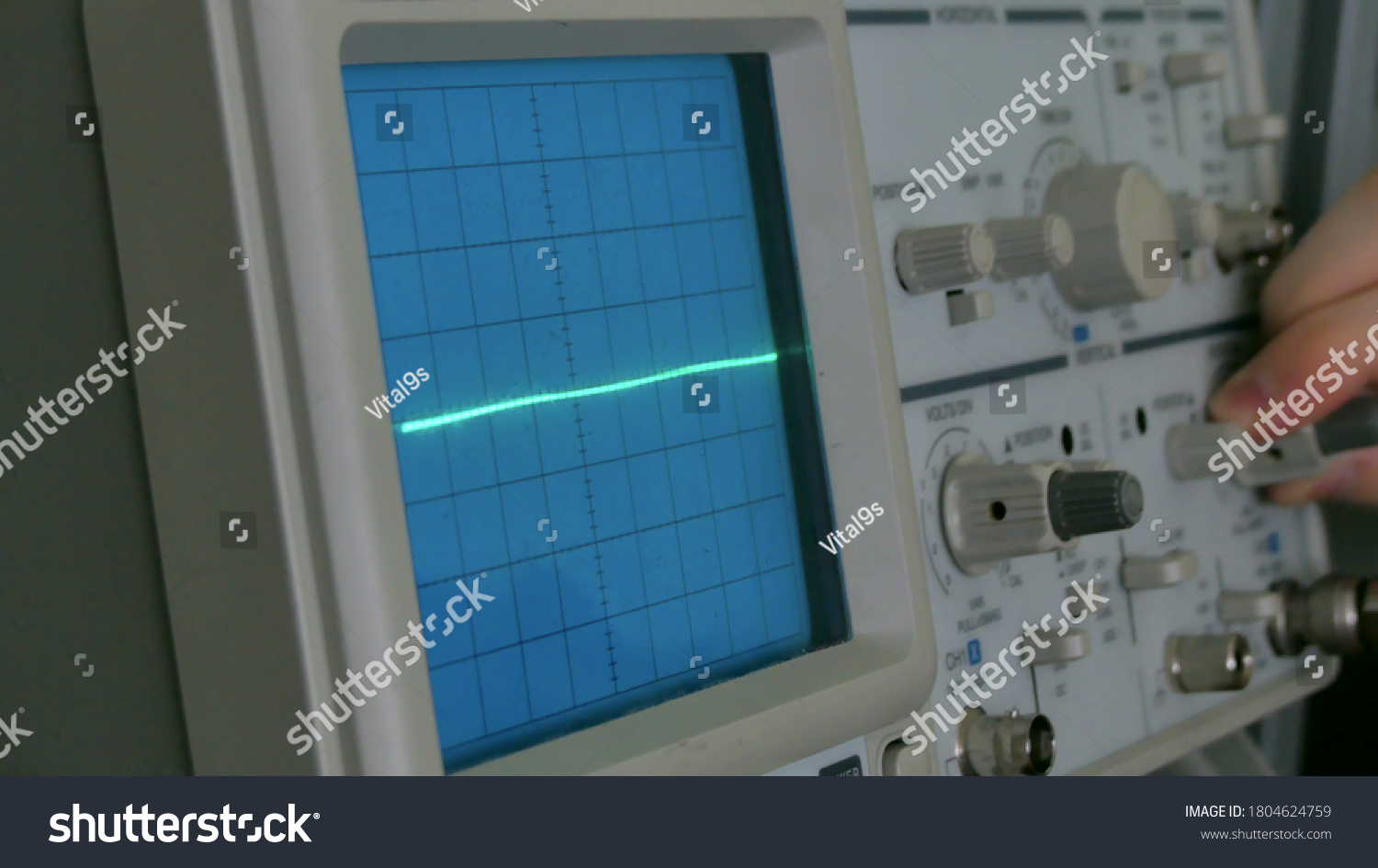 Amplitude Diagram on the oscilloscope. A man presses the buttons on the device. The geometric line changes shape #1804624759