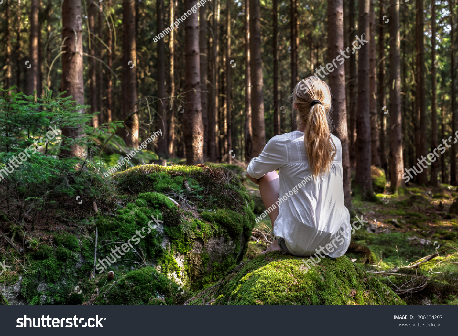 Woman sitting in green forest enjoys the silence and beauty of nature. #1806334207
