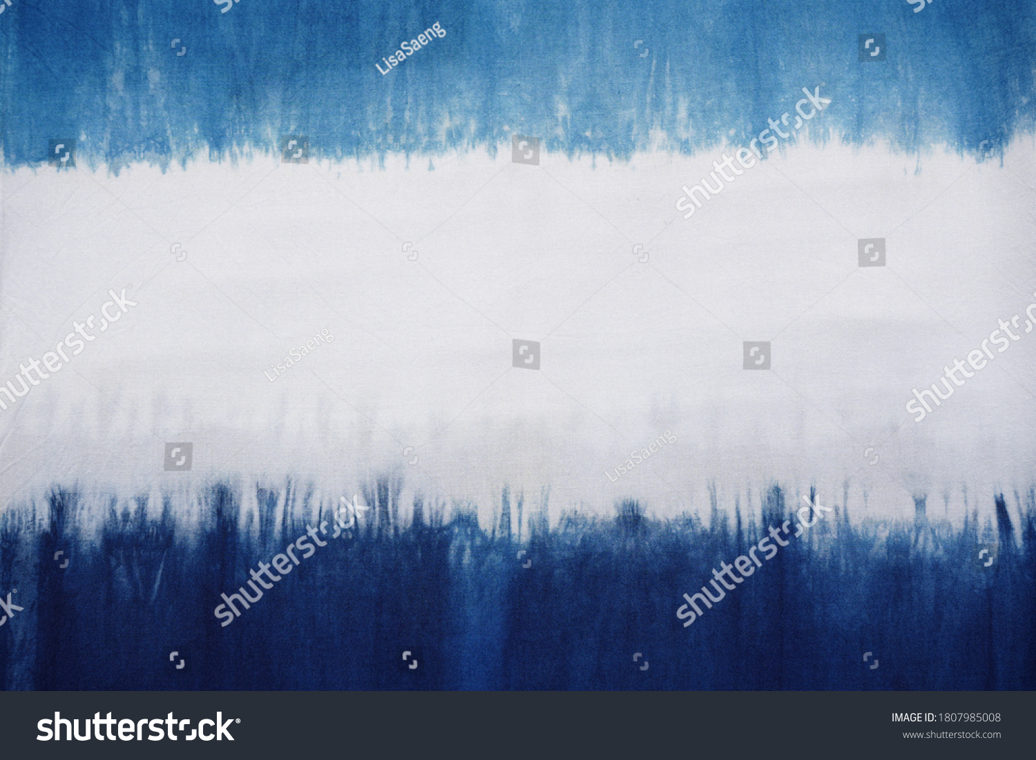 A natural indigo dye on cotton fabric showing color flow and its pattern.  Horizontal blue and white. At center is good for texts, copy space and advertisement. Material, object, background, design.   #1807985008