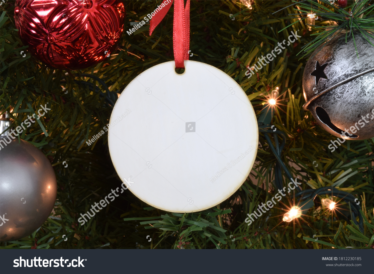 Blank Round Christmas Ornament hanging from a lit up Christmas tree surrounded by ornaments.  #1812230185