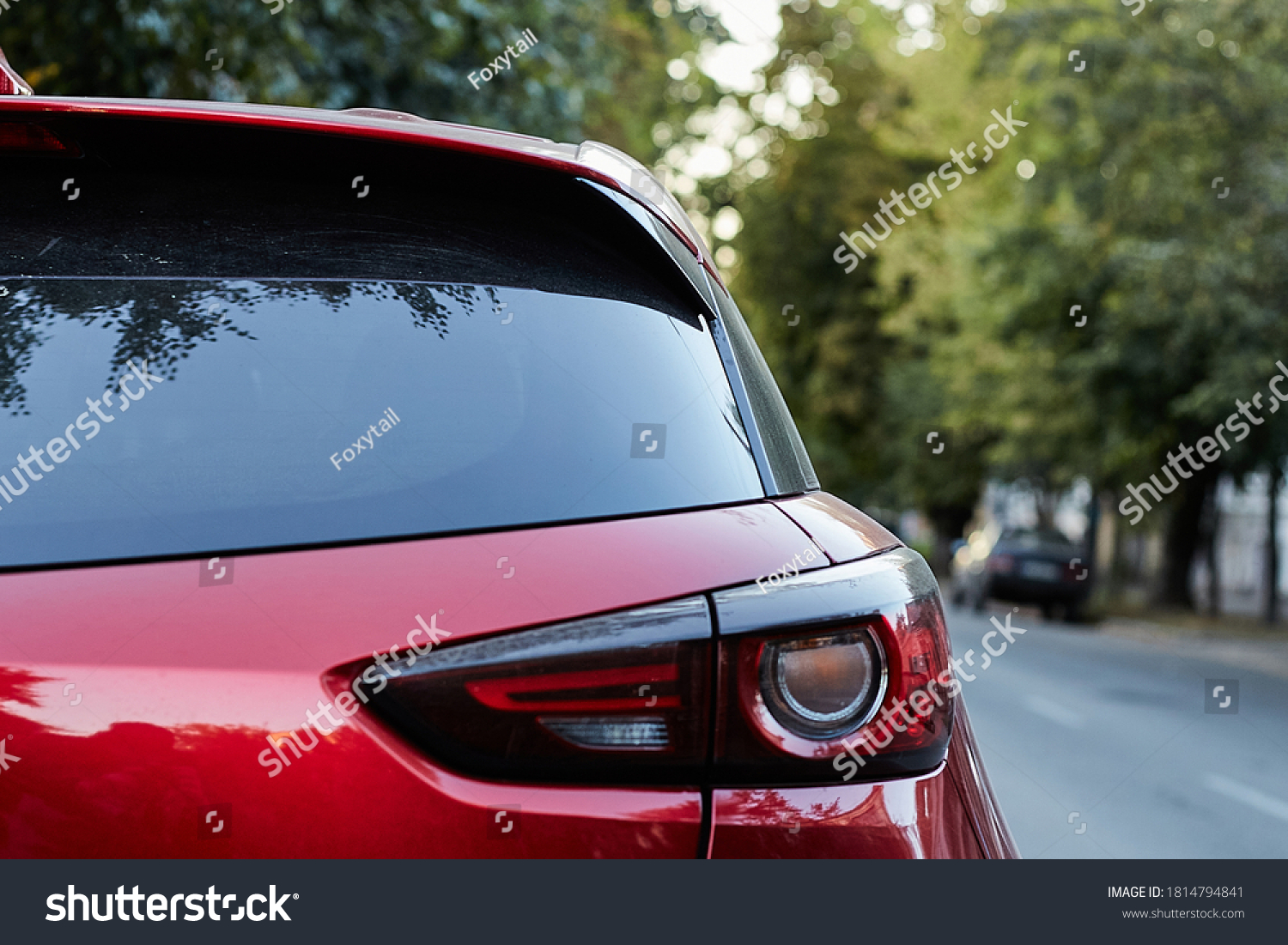Back window of red car parked on the street in summer sunny day, rear view. Mock-up for sticker or decals #1814794841