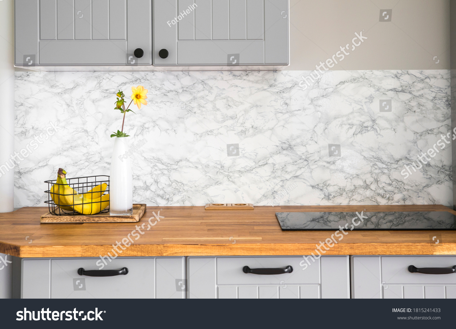 Modern minimal gray color kitchen with self adhesive fake marble imitation tape on wall, solid natural wood countertop with built in small stove. #1815241433