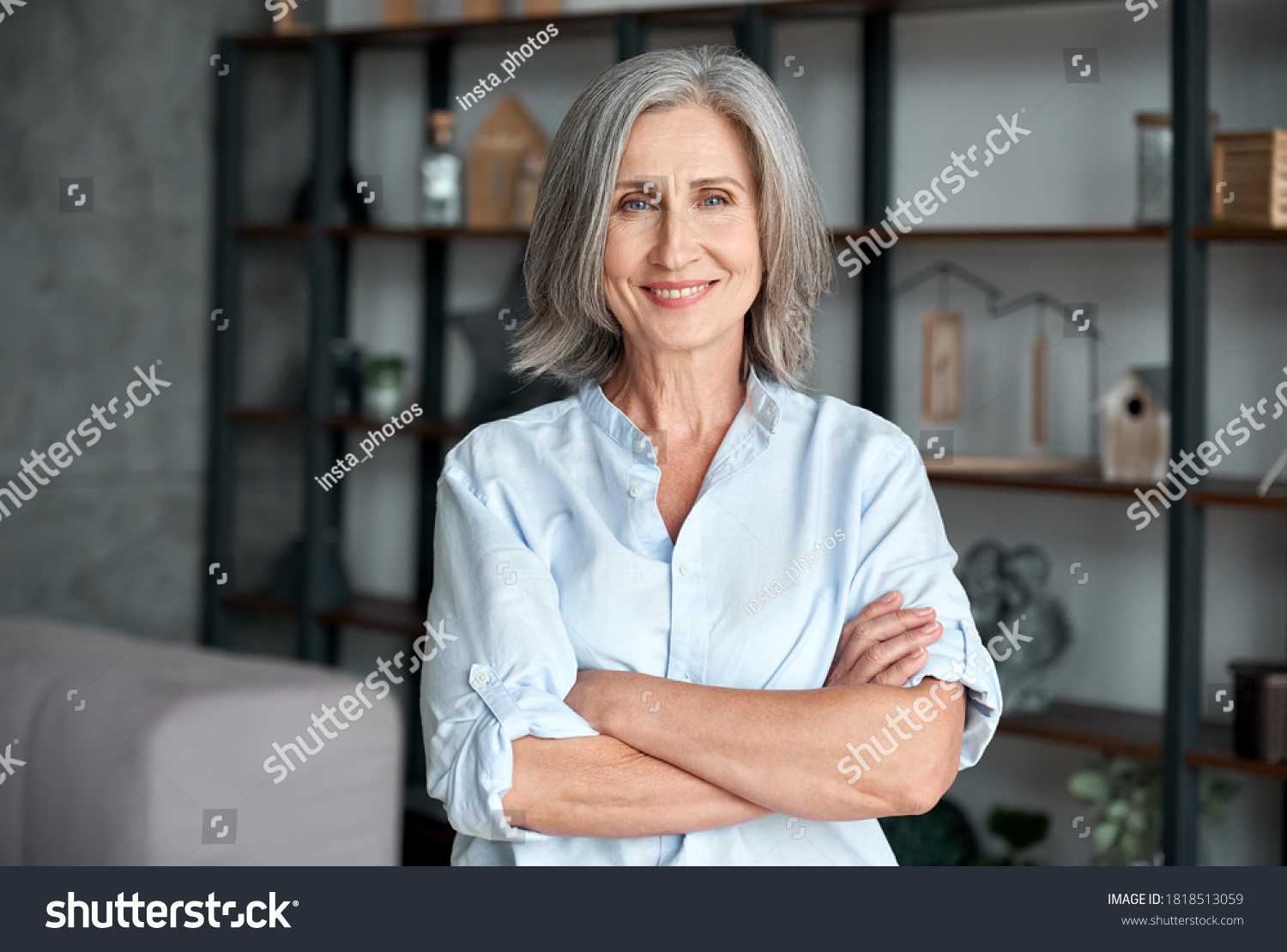 Smiling confident stylish mature middle aged woman standing at home office. Old senior businesswoman, 60s gray-haired lady executive business leader manager looking at camera arms crossed, portrait. #1818513059