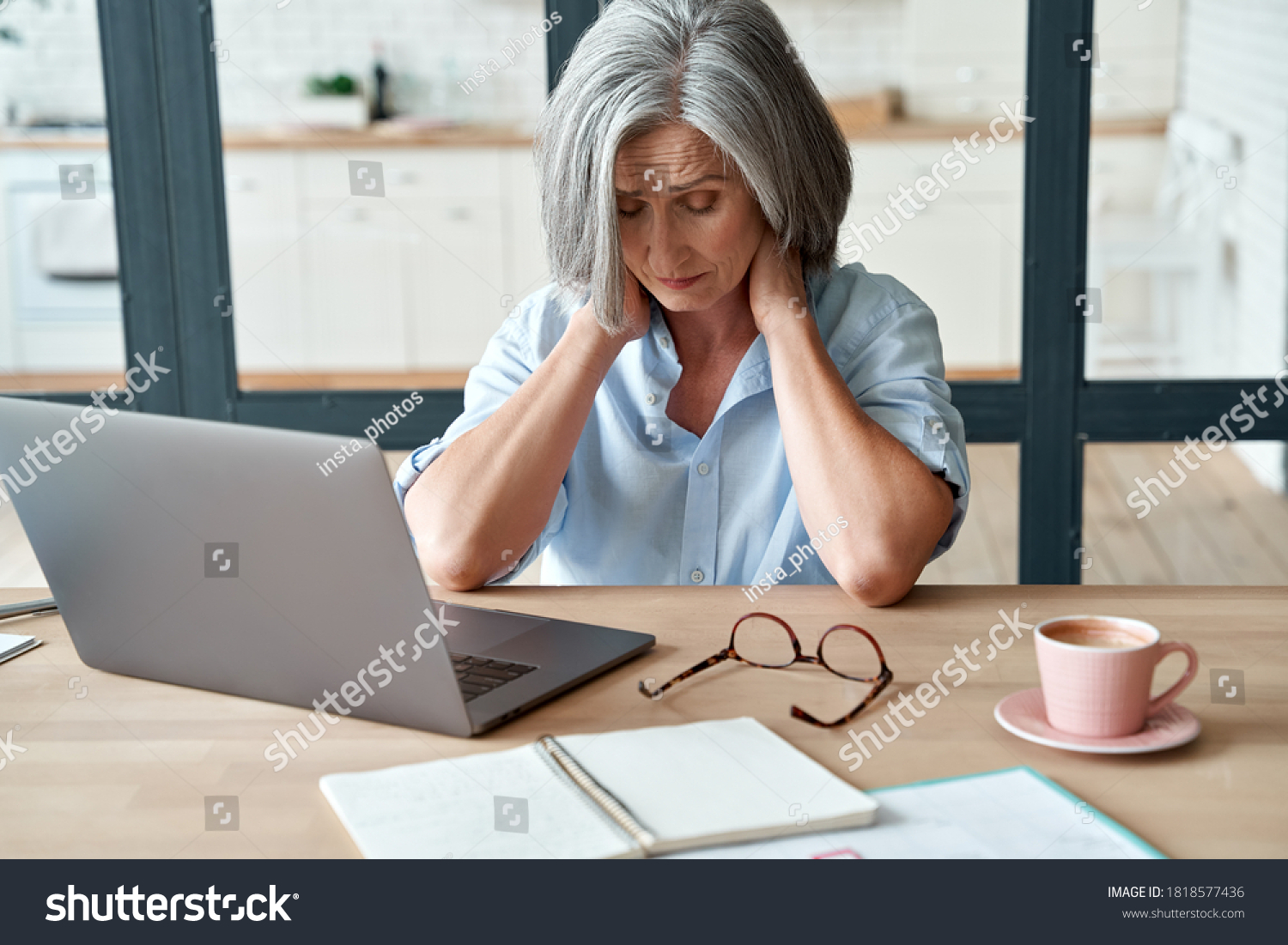 Tired stressed old mature business woman suffering from neckpain working from home office sitting at table. Overworked senior middle aged lady massaging neck feeling hurt pain from incorrect posture. #1818577436