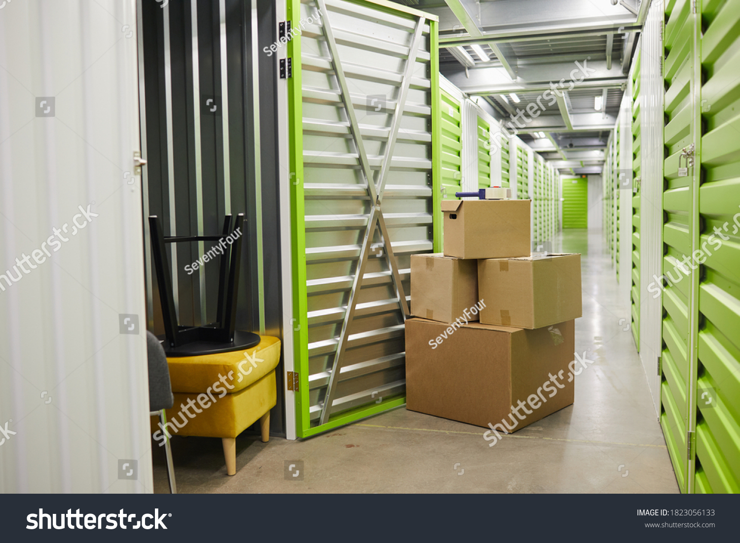 Background image of cardboard boxes stacked by open door of self storage unit, copy space #1823056133