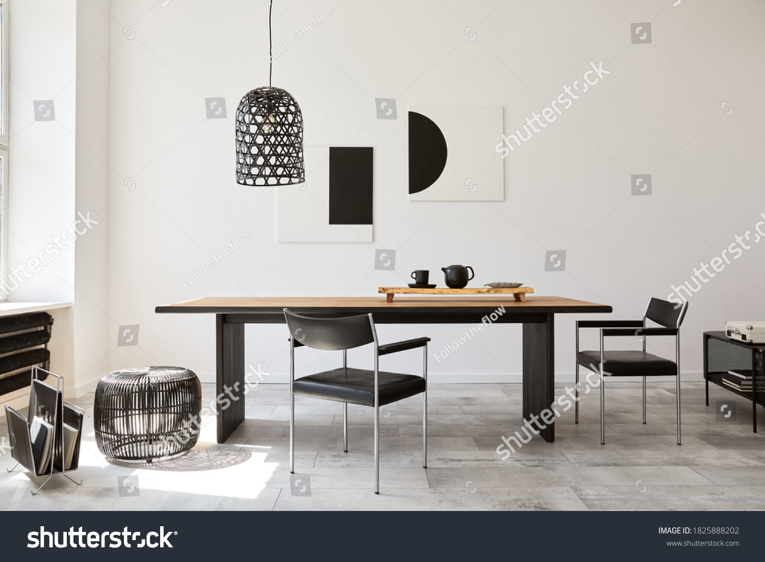 Stylish dining room interior with design wooden family table, black chairs, teapot with mug, mock up art paintings on the wall and elegant accessories in modern home decor. Template. #1825888202