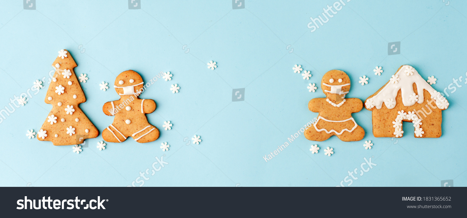 Happy New Year's set of numbers 2022, gingerbread man in face mask from ginger biscuits glazed sugar icing decoration on blue background, minimal seasonal pandemic winter holiday banner #1831365652