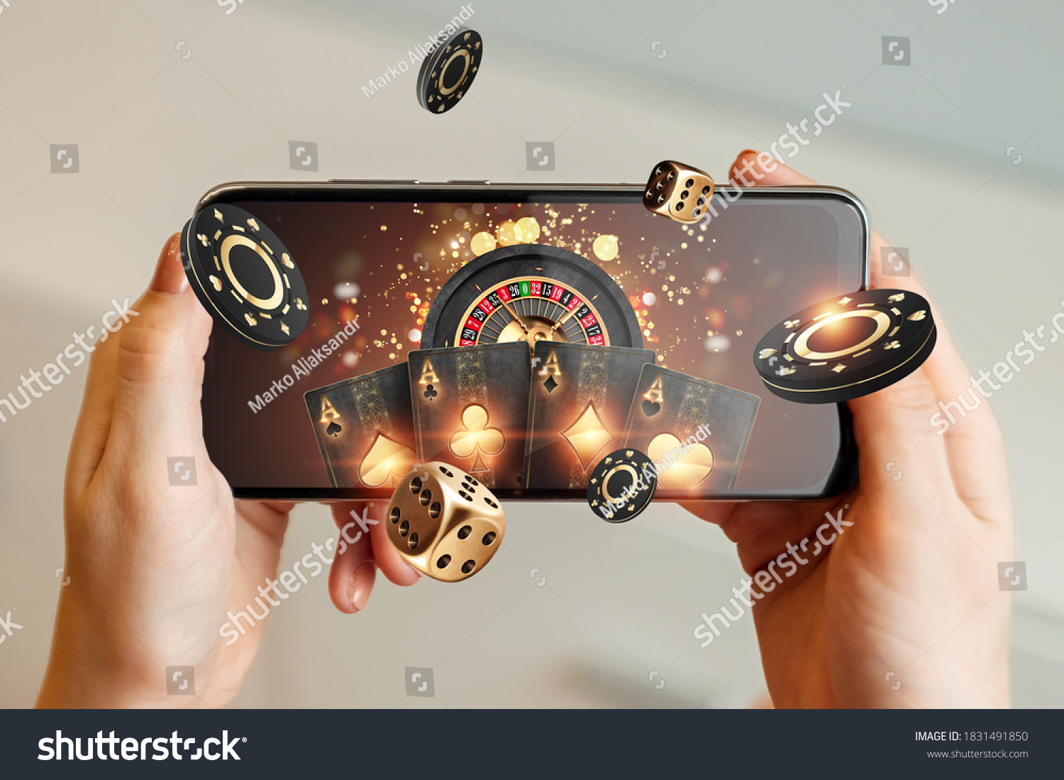 Creative background, online casino, in a man's hand a smartphone with playing cards, roulette and chips, black-gold background. Internet gambling concept. Copy space. #1831491850