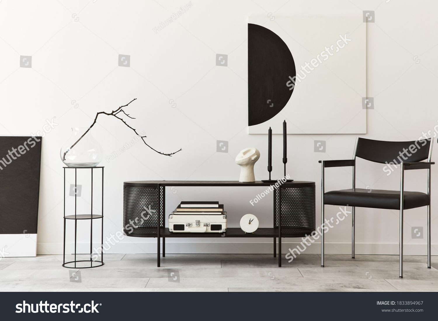 Interior design of modern living room with black stylish commode, chair, mock up art paintings, lamp, book, candlestick, decorations and elegant accessories in home decor. Template. #1833894967