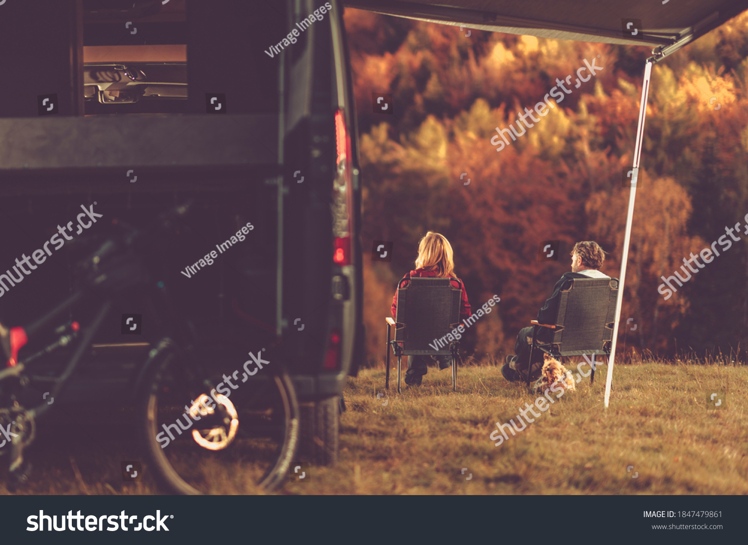 Scenic Fall Foliage RV Camper Camping. Caucasian Couple Seating Next to Their Motorhome and Enjoying the Scenery. Campsite Pitch. #1847479861