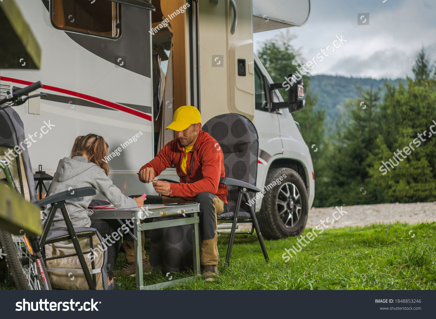 Caucasian Father with His Daughter Hanging Next to Modern Camper Van Class C Motorhome. Family RV Park Camping Theme. #1848853246