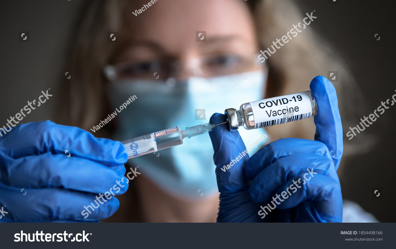 COVID-19 vaccine in researcher hands, female doctor's holds syringe and bottle with vaccine for coronavirus cure. Concept of corona virus treatment, injection, shot and clinical trial during pandemic #1854498166