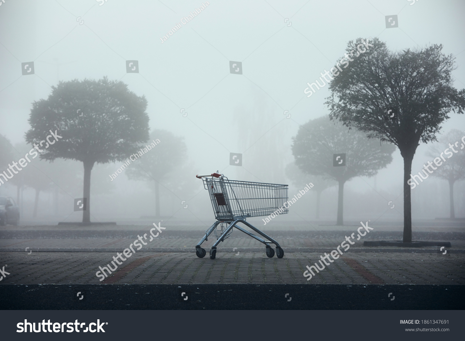 Abandoned shopping cart on parking lot in thick fog. Themes shopping, financial crisis and gloomy weather. #1861347691