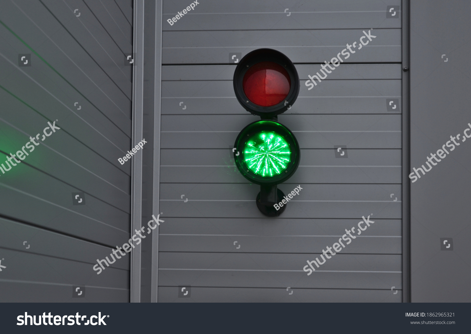 traffic light with two lights. placed on a metal gray facade of a garage or warehouse. used to enter trucks to the loading ramp for goods. regulates the entrance to the garages of the shopping center #1862965321