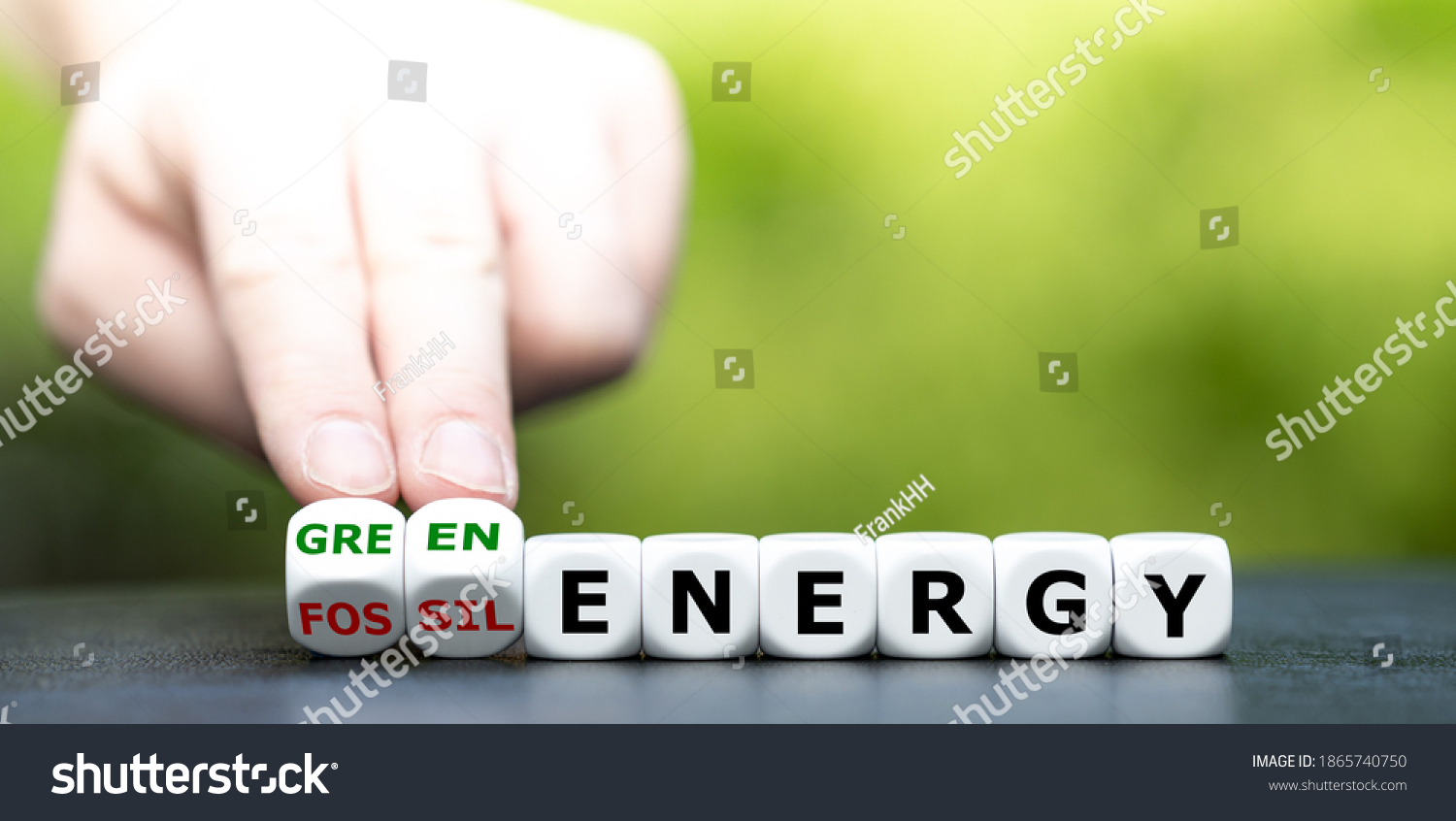 Hand turns dice and changes the expression "fossil energy" to "green energy". #1865740750