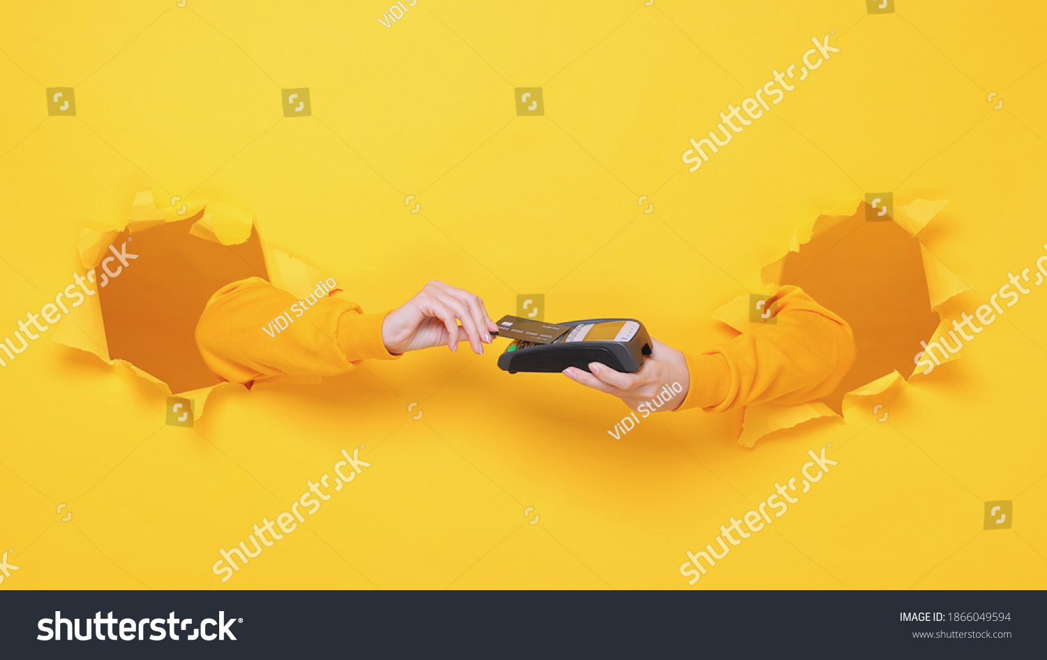 Close up cropped female hand hold wireless bank terminal to process acquire credit card payments pay isolated through torn yellow background studio Copy space place for text or image workspace mock up #1866049594
