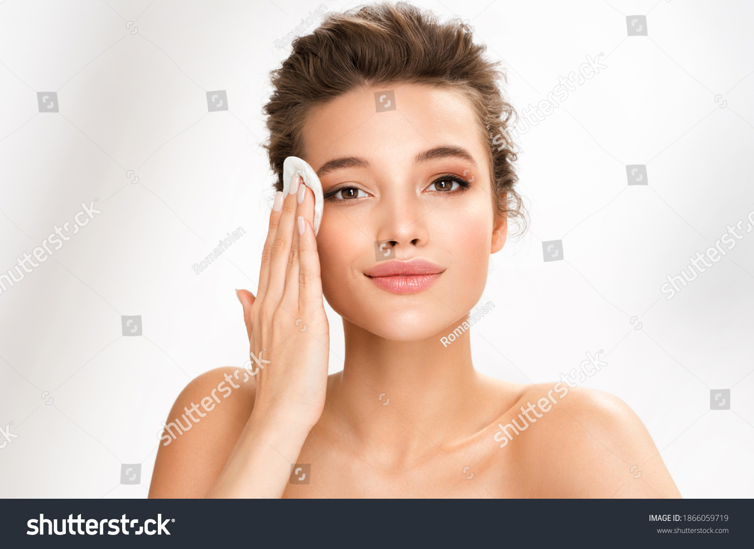 Woman removing makeup, holds cotton pads near face. Photo of woman with perfect skin on white background. Beauty and skin care concept #1866059719