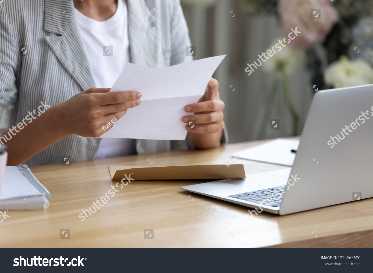 Getting news by mail. Close up of young lady involved in paperwork at home office studio hold paper letter in hands. Businesswoman get message out of envelop read information from bank client supplier #1874663680