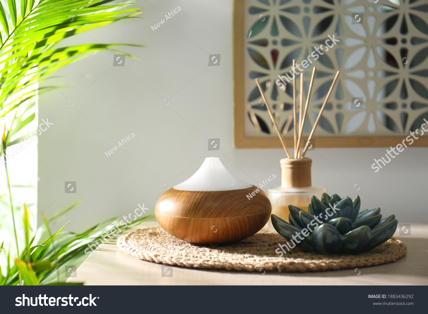 Aroma oil diffuser and reed air freshener on table in room #1883436292