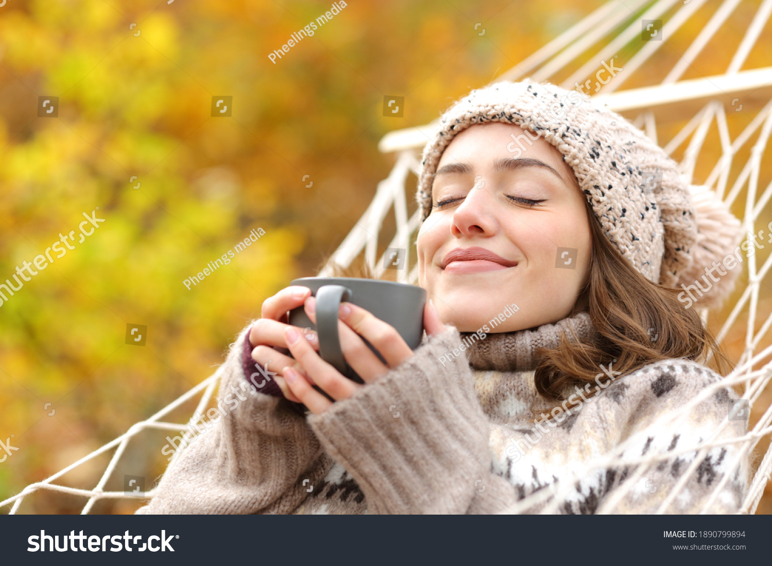 Relaxed woman smelling coffee lying on hammock in autumn holidays #1890799894