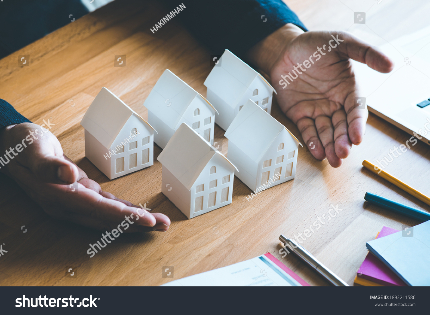 Business property,real estate and investment concepts with investor and white model house on desk background. #1892211586