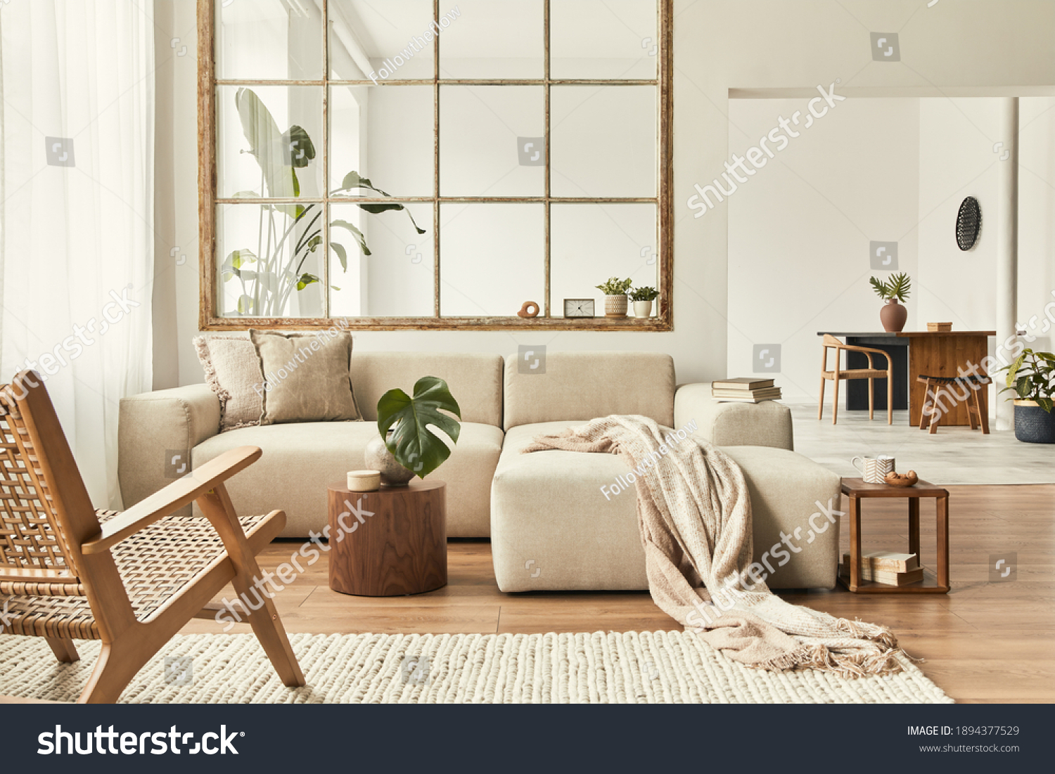 Modern interior of open space with design modular sofa, furniture, wooden coffee tables, plaid, pillows, tropical plants and elegant personal accessories in stylish home decor. Neutral living room. #1894377529