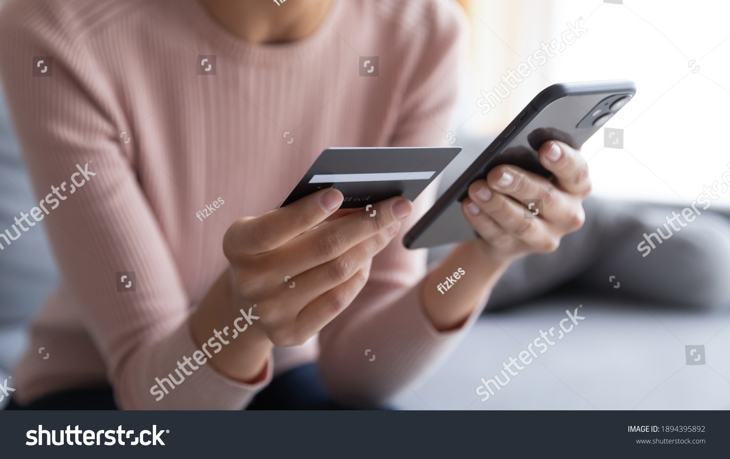 Close up female hands holding credit card and smartphone, young woman paying online, using banking service, entering information, shopping, ordering in internet store, doing secure payment #1894395892