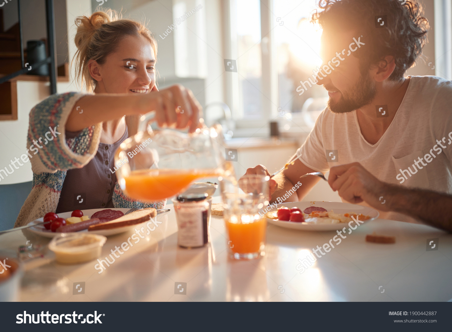 Happy couple having breakfast together in the kitchen #1900442887